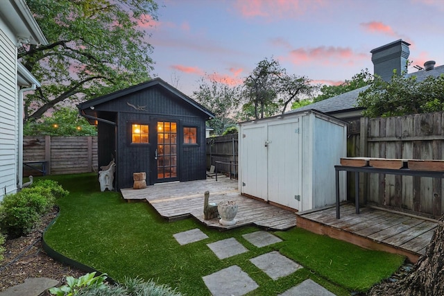 505 N College St, Mckinney, TX 75069 - back of house at dusk featuring an outdoor structure and a wooden deck