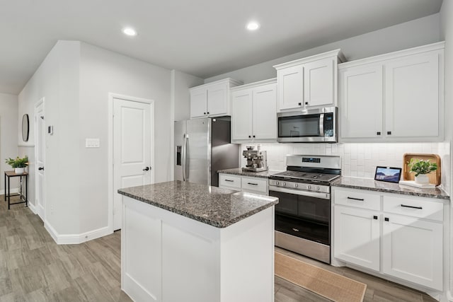 1601 Stetson St, Northlake, TX 76247 - kitchen with stainless steel appliances, dark stone countertops, a center island, white cabinets, and recessed lighting