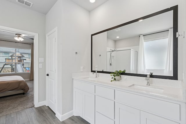 1601 Stetson St, Northlake, TX 76247 - bathroom featuring a stall shower, double vanity, wood finished floors, baseboards, and a ceiling fan