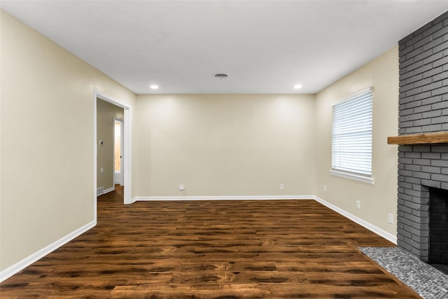 2302 Mockingbird Ln, Garland, TX 75042 - unfurnished living room featuring dark wood-style flooring, a brick fireplace, baseboards, and recessed lighting