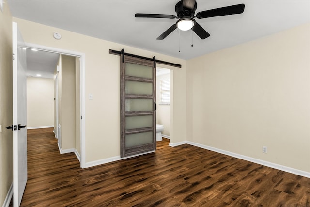 2302 Mockingbird Ln, Garland, TX 75042 - unfurnished bedroom with dark wood-style flooring, a barn door, baseboards, and ceiling fan