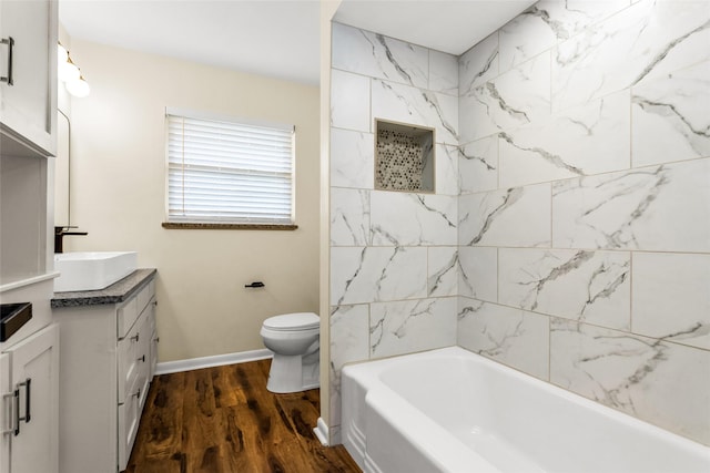 2302 Mockingbird Ln, Garland, TX 75042 - full bathroom with vanity, toilet, wood finished floors, and baseboards