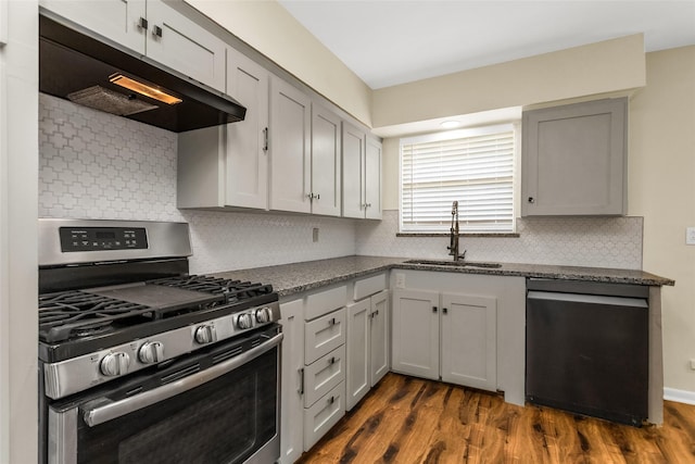 2302 Mockingbird Ln, Garland, TX 75042 - kitchen with stainless steel range with gas stovetop, dishwasher, a sink, under cabinet range hood, and dark wood-style flooring
