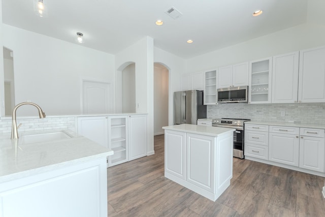 2025 Scott Creek Dr, Little Elm, TX 75068 - kitchen featuring appliances with stainless steel finishes, a sink, a center island, open shelves, and decorative backsplash