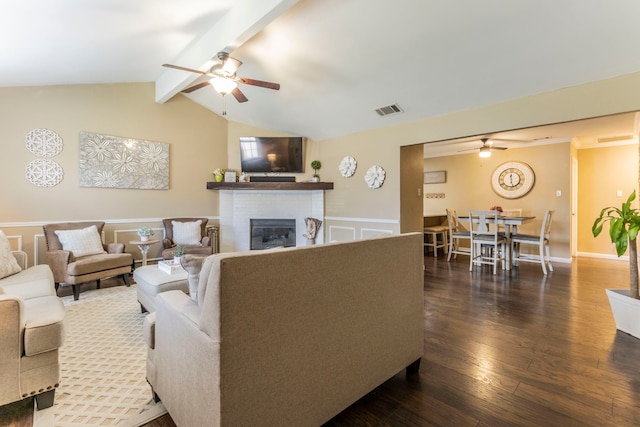 8713 Trinity Vista Trl, Fort Worth, TX 76053 - living room featuring ceiling fan, a fireplace, a wainscoted wall, dark wood-type flooring, and a decorative wall