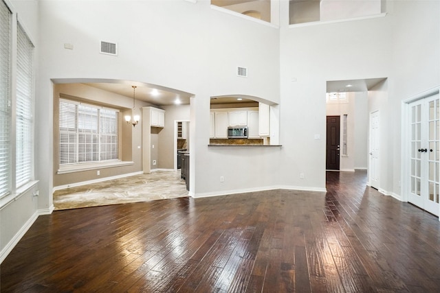 3112 Myrtice Dr, Flower Mound, TX 75022 - unfurnished living room with a towering ceiling, wood-type flooring, a chandelier, and plenty of natural light