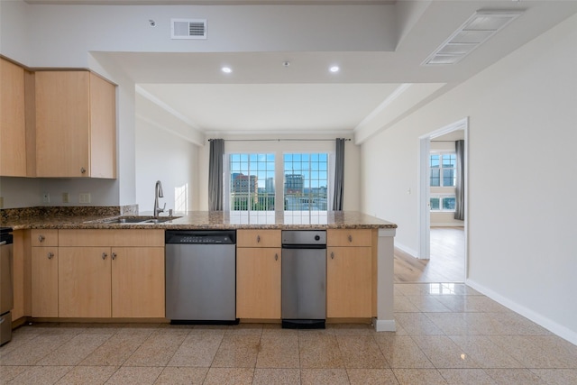 3225 Turtle Creek Blvd Unit 1012, Dallas, TX 75219 - kitchen featuring dishwasher, light brown cabinets, a peninsula, a sink, and baseboards