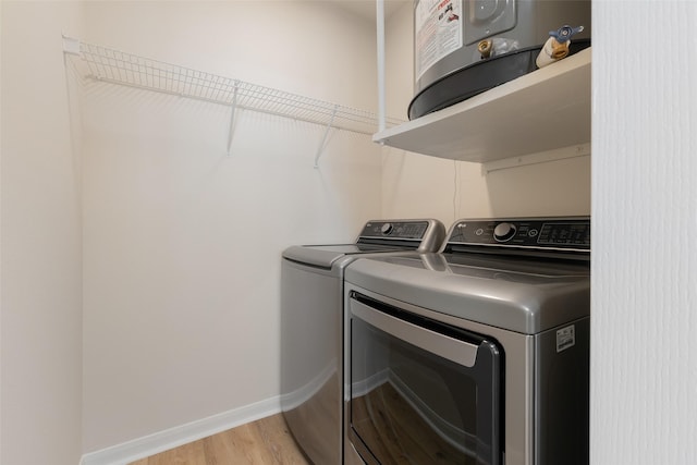 3225 Turtle Creek Blvd Unit 1012, Dallas, TX 75219 - laundry area featuring washing machine and dryer, light wood finished floors, and baseboards