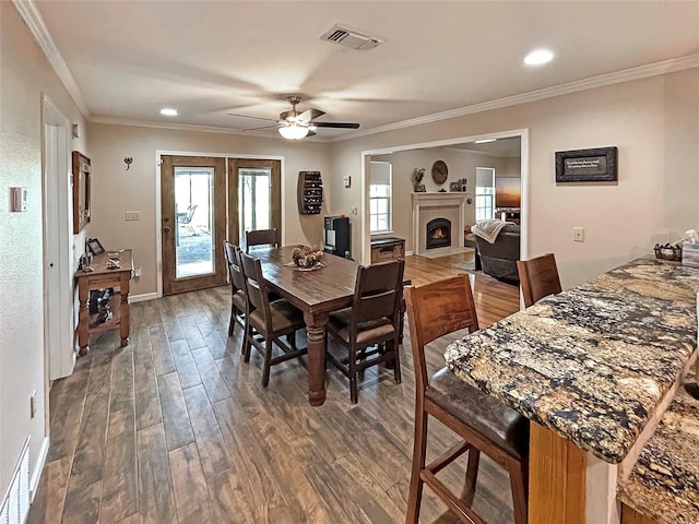 434 Thornton Ln, Palo Pinto, TX 76484 - dining space featuring healthy amount of natural light, wood finished floors, a fireplace with flush hearth, ceiling fan, and ornamental molding