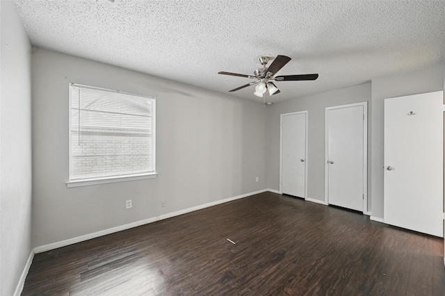 815 Quail Ter, Mansfield, TX 76063 - unfurnished bedroom with dark wood-style flooring, a textured ceiling, two closets, baseboards, and ceiling fan