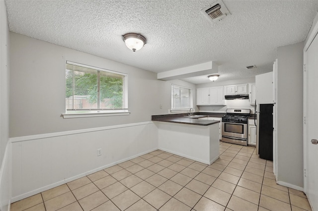 815 Quail Ter, Mansfield, TX 76063 - kitchen with stainless steel range with gas cooktop, under cabinet range hood, a sink, freestanding refrigerator, and a peninsula
