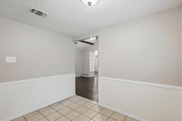 815 Quail Ter, Mansfield, TX 76063 - spare room with a textured ceiling, wainscoting, and light tile patterned floors