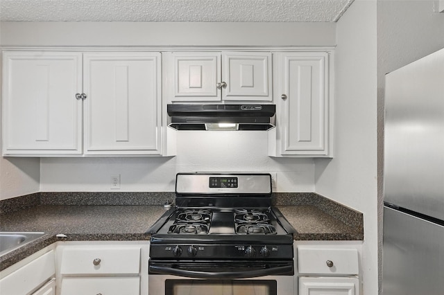 815 Quail Ter, Mansfield, TX 76063 - kitchen with under cabinet range hood, stainless steel appliances, white cabinets, dark countertops, and a textured ceiling