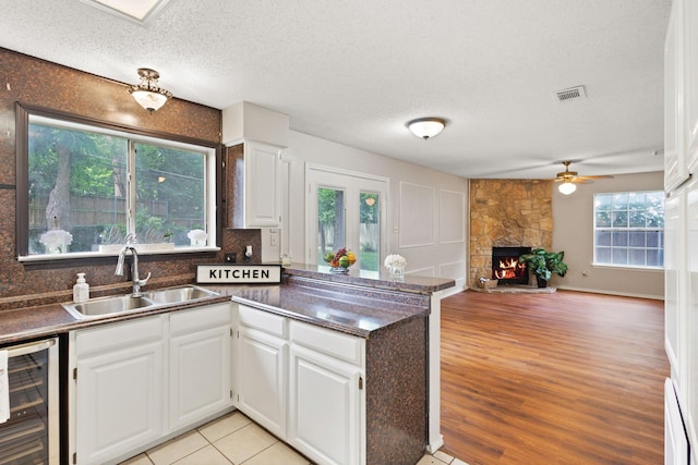 1019 W Lovers Ln W, Arlington, TX 76013 - kitchen with a sink, wine cooler, dark countertops, a peninsula, and ceiling fan