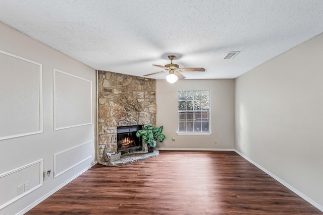 1019 W Lovers Ln W, Arlington, TX 76013 - unfurnished living room featuring ceiling fan, wood finished floors, a fireplace, a textured ceiling, and baseboards