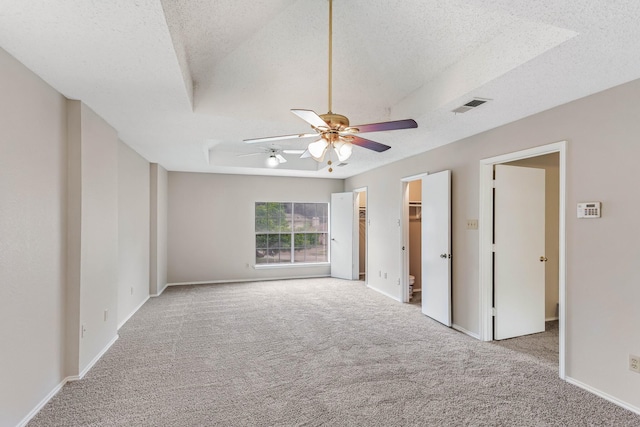 1019 W Lovers Ln W, Arlington, TX 76013 - unfurnished bedroom with a textured ceiling, carpet floors, a raised ceiling, a walk in closet, and baseboards
