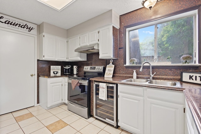 1019 W Lovers Ln W, Arlington, TX 76013 - kitchen with stainless steel electric range, beverage cooler, under cabinet range hood, dark countertops, and white cabinets