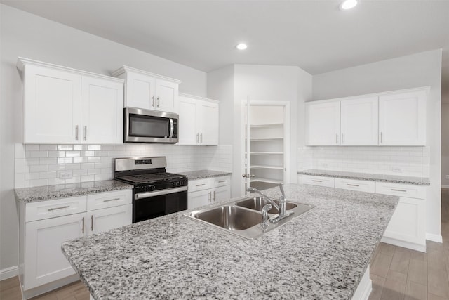 9653 Alderleaf Trl, Fort Worth, TX 76036 - kitchen featuring appliances with stainless steel finishes, a sink, light wood finished floors, white cabinets, and recessed lighting