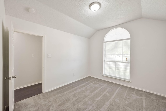 7405 Mesa Verde Trl, Fort Worth, TX 76137 - carpeted spare room featuring vaulted ceiling, a textured ceiling, a smoke detector, and baseboards