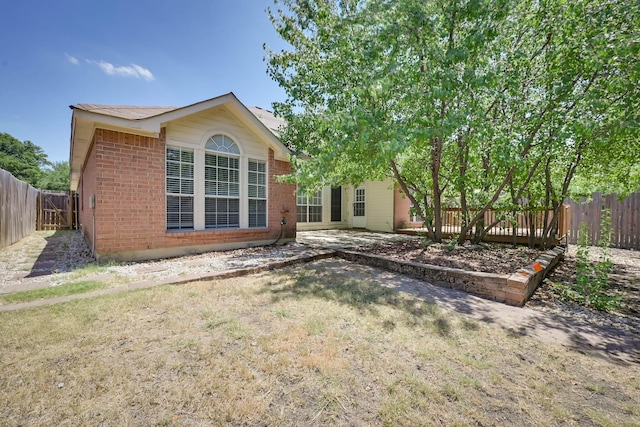 7405 Mesa Verde Trl, Fort Worth, TX 76137 - back of property with brick siding, a fenced backyard, and a patio area
