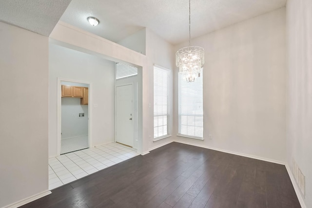 7405 Mesa Verde Trl, Fort Worth, TX 76137 - unfurnished dining area with wood-type flooring, a chandelier, baseboards, and a textured ceiling
