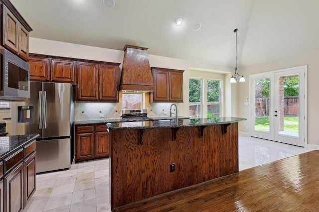 205 Hogue Ln, Wylie, TX 75098 - kitchen featuring stainless steel appliances, premium range hood, a kitchen breakfast bar, dark stone countertops, and backsplash