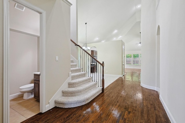 205 Hogue Ln, Wylie, TX 75098 - stairway with wood-type flooring, arched walkways, lofted ceiling, a ceiling fan, and baseboards