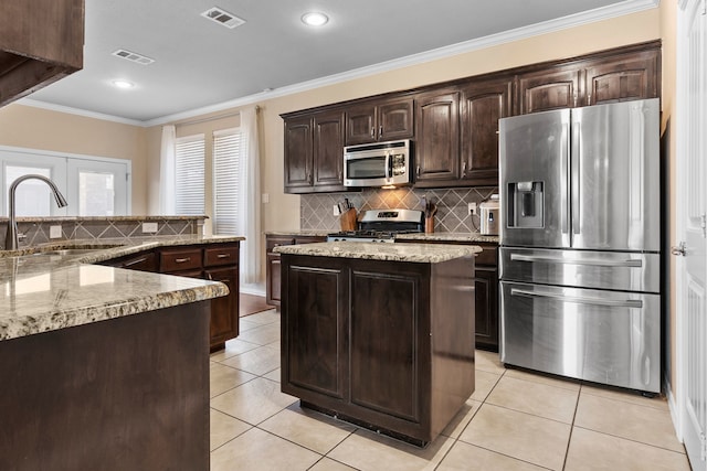 12001 Walden Wood Dr, Fort Worth, TX 76244 - kitchen with appliances with stainless steel finishes, a sink, a kitchen island, dark brown cabinets, and light tile patterned floors
