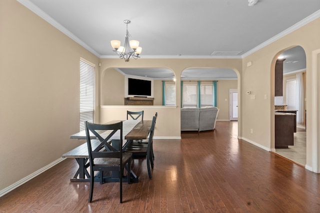 12001 Walden Wood Dr, Fort Worth, TX 76244 - dining area with arched walkways, wood finished floors, a chandelier, baseboards, and crown molding