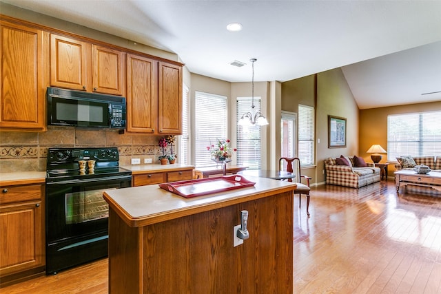3801 Emerald Park Dr, Corinth, TX 76208 - kitchen featuring black appliances, a kitchen island, light wood-type flooring, tasteful backsplash, and open floor plan
