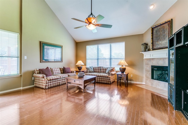 3801 Emerald Park Dr, Corinth, TX 76208 - living room with ceiling fan, healthy amount of natural light, wood finished floors, a tiled fireplace, and high vaulted ceiling