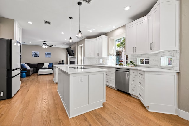 2600 Shadow Hill Ln, Plano, TX 75093 - kitchen with stainless steel dishwasher, open floor plan, black electric cooktop, freestanding refrigerator, and tasteful backsplash