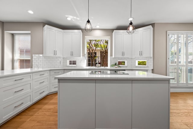 2600 Shadow Hill Ln, Plano, TX 75093 - kitchen featuring black electric cooktop, a kitchen island, white cabinetry, decorative backsplash, and recessed lighting