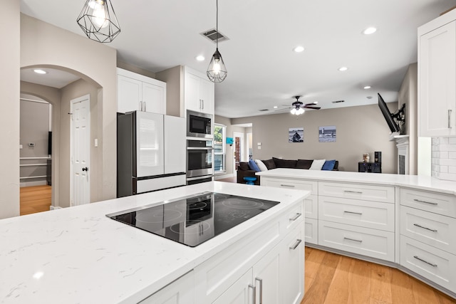 2600 Shadow Hill Ln, Plano, TX 75093 - kitchen featuring appliances with stainless steel finishes, arched walkways, recessed lighting, white cabinets, and light stone counters