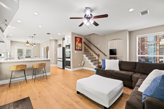2600 Shadow Hill Ln, Plano, TX 75093 - living area with arched walkways, ceiling fan, light wood-style floors, recessed lighting, and stairs