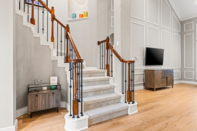 2600 Shadow Hill Ln, Plano, TX 75093 - stairway with wood finished floors, a decorative wall, ornamental molding, baseboards, and a towering ceiling