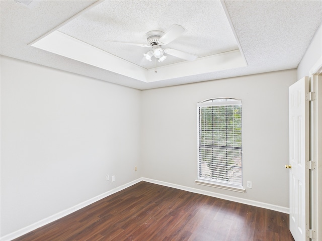1120 Canyon Ridge Dr, Desoto, TX 75115 - unfurnished room featuring a tray ceiling, dark wood-style floors, a textured ceiling, baseboards, and ceiling fan