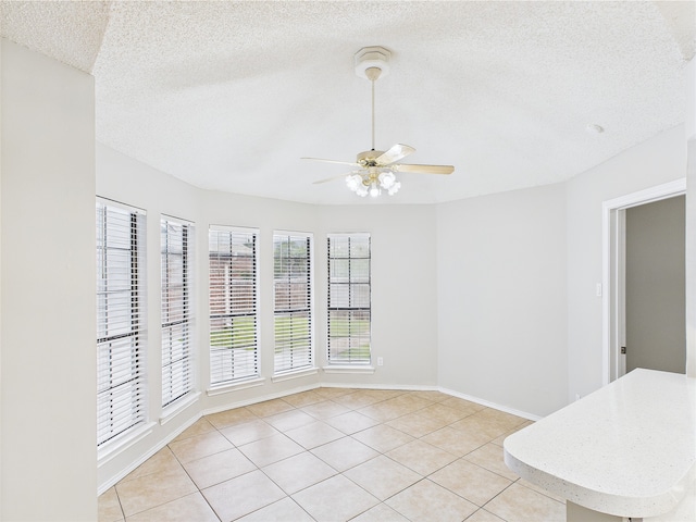 1120 Canyon Ridge Dr, Desoto, TX 75115 - spare room with a ceiling fan, a textured ceiling, light tile patterned flooring, and baseboards