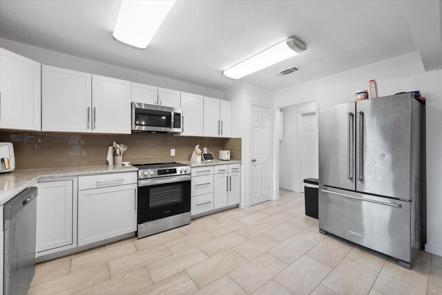 7209 W Cleburne Rd, Fort Worth, TX 76133 - kitchen with appliances with stainless steel finishes, backsplash, white cabinets, and light stone counters