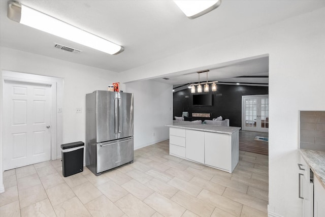 7209 W Cleburne Rd, Fort Worth, TX 76133 - kitchen featuring freestanding refrigerator, white cabinets, light countertops, and decorative light fixtures