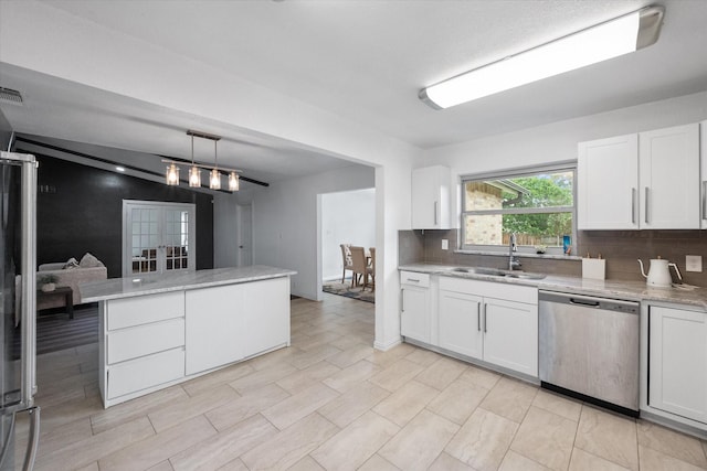 7209 W Cleburne Rd, Fort Worth, TX 76133 - kitchen with stainless steel dishwasher, a sink, decorative backsplash, white cabinets, and decorative light fixtures