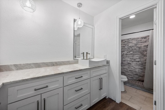 7209 W Cleburne Rd, Fort Worth, TX 76133 - bathroom featuring vanity, toilet, tiled shower, and wood finished floors