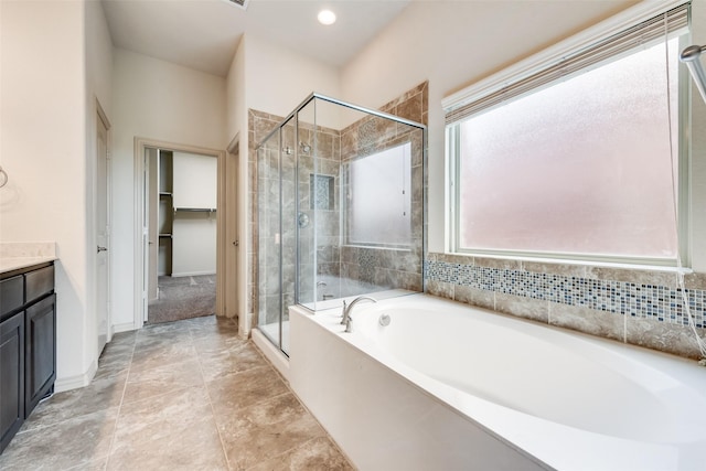9641 Calaveras Rd, Fort Worth, TX 76177 - bathroom with a shower stall, a garden tub, vanity, a spacious closet, and baseboards