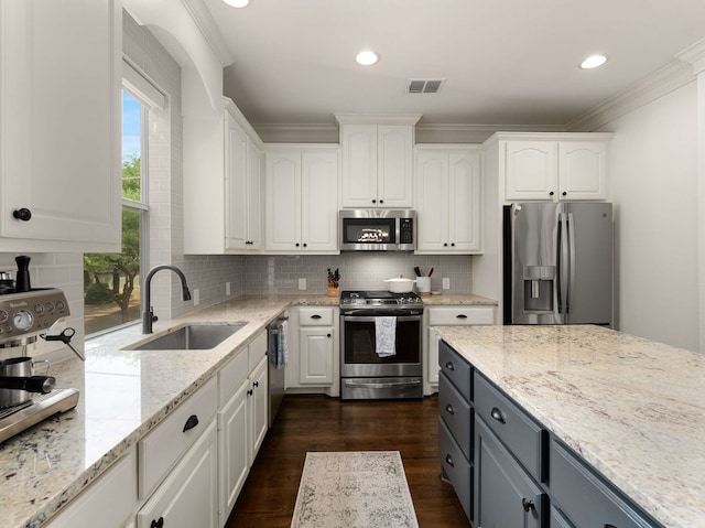 2917 Hallsville St, Dallas, TX 75204 - kitchen with stainless steel appliances, a sink, white cabinets, light stone countertops, and tasteful backsplash