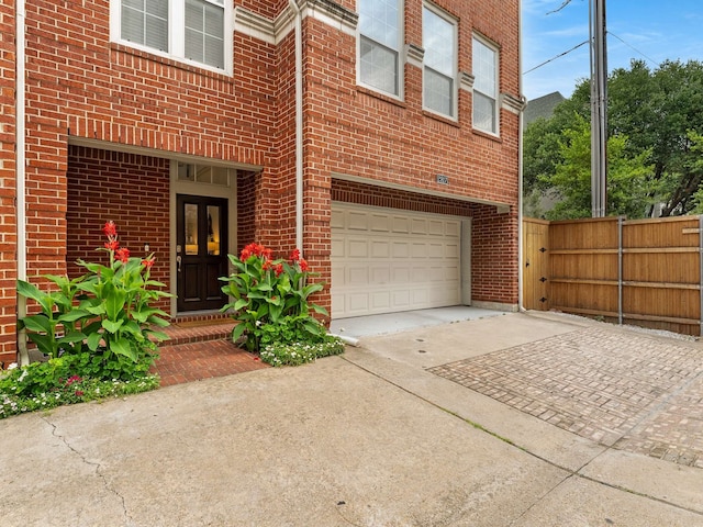 2917 Hallsville St, Dallas, TX 75204 - doorway to property with driveway, an attached garage, and brick siding