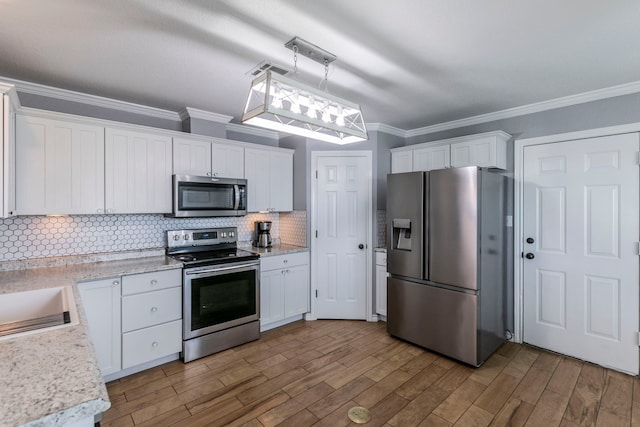 4260 Gun Club Rd, Temple, TX 76501 - kitchen with stainless steel appliances, crown molding, white cabinetry, and backsplash