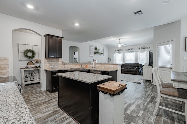 273 Pitt Cir, Fate, TX 75189 - kitchen with arched walkways, ceiling fan, light wood-style flooring, backsplash, and a kitchen island