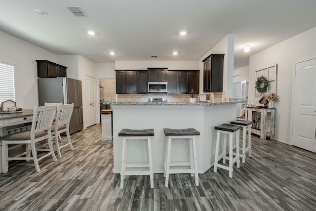273 Pitt Cir, Fate, TX 75189 - kitchen featuring stainless steel appliances, wood finished floors, dark brown cabinets, tasteful backsplash, and recessed lighting