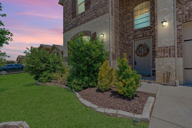 273 Pitt Cir, Fate, TX 75189 - doorway to property featuring stone siding, a lawn, and brick siding