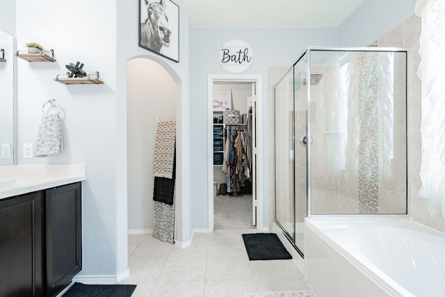 273 Pitt Cir, Fate, TX 75189 - full bathroom featuring a stall shower, a garden tub, a spacious closet, vanity, and tile patterned flooring